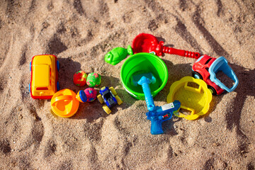 Colorful children's beach toys arranged on the sand © Eldin