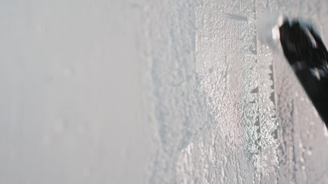 Person applying white plaster to wall with metal spatula during home renovation.