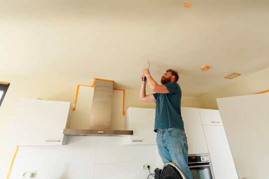 Man Works on Ceiling at Home