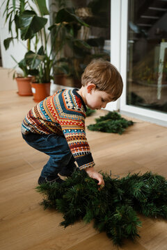 A toddler makes the Christmas tree at home