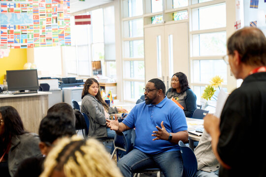 Black male teacher talking to coworkers