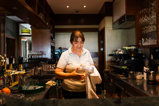 Restaurant Worker Polishing Glassware Behind the Bar