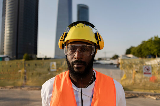 African construction worker with safety gear standing on site