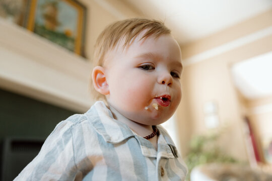 Candid toddler eating snack with messy face