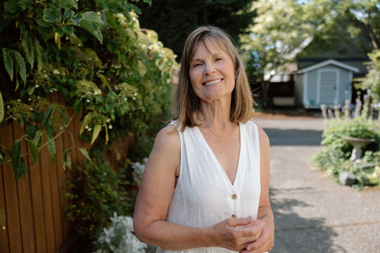 Candid portrait of a happy mature woman in backyard garden