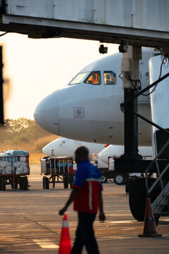 Airport Ground Crew Walking Past Parked Airplane
