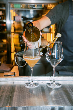 Pouring a glass of white wine from a bottle mock up. Wine glasses