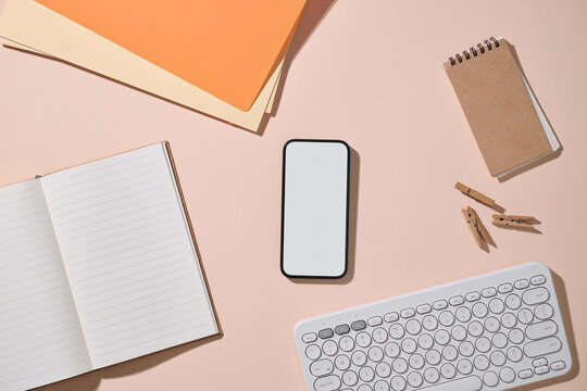 Workspace with phone, notebook, and keyboard