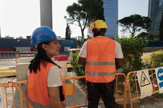 Diverse construction workers supervising urban building site