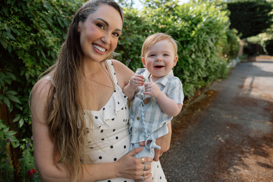 Mother holding baby outdoors in candid affectionate moment