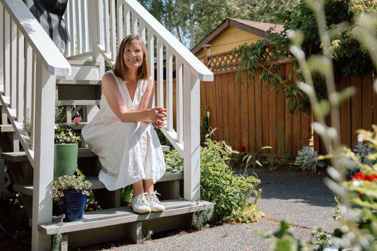 Candid portrait of a smiling woman sitting on porch steps