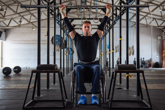 Wheelchair Athlete Performing Overhead Pull-Up In Gym