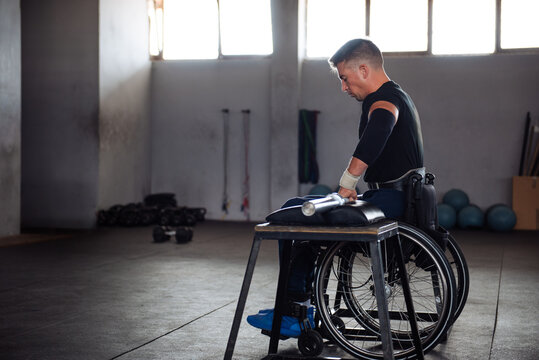 Wheelchair Athlete Training in Gym With Barbell