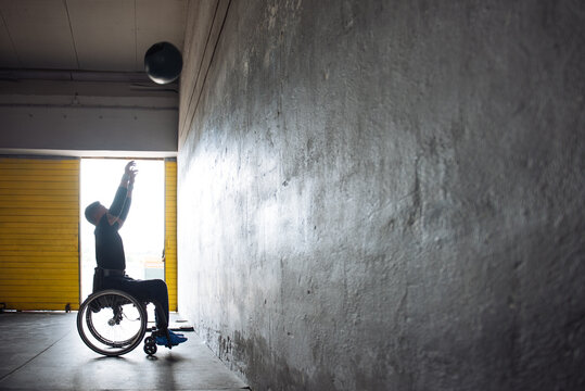 Wheelchair Athlete Training With Medicine Ball In Gym