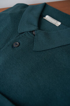 Close view of a green polo shirt on a wooden surface