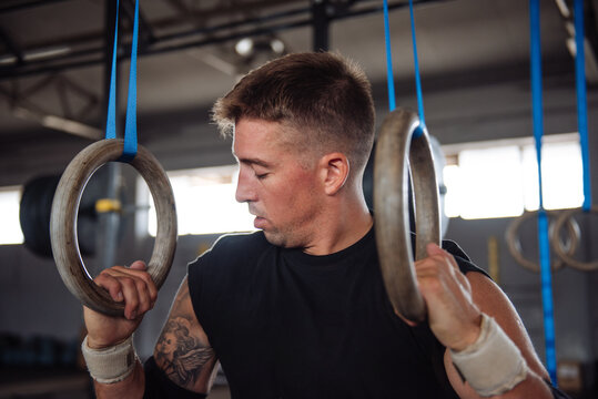 Athlete Training on Gym Rings in Fitness Gym