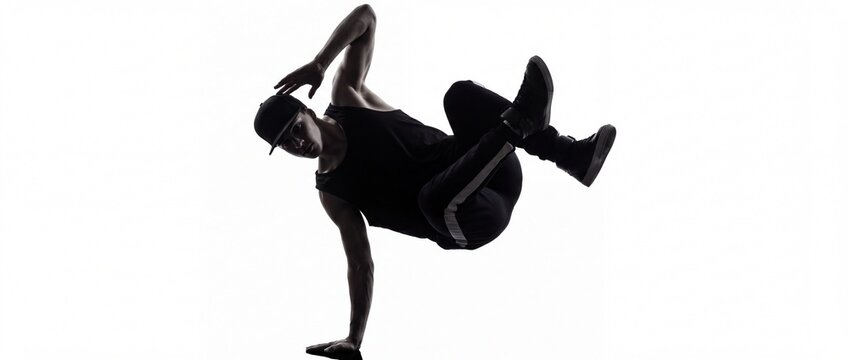Silhouette of a male breakdancer balancing on one hand against a white background