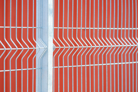 Modern galvanized steel wire mesh fence with brown wall background, Perspective side view with copy space