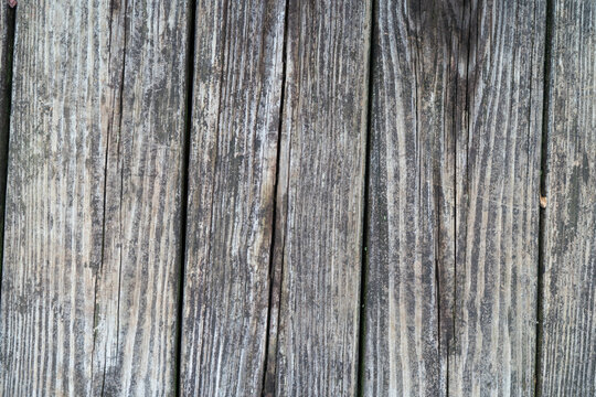 Overhead flat lay view of worn wooden background. Dry rot affected outdoor wood planks and boards of an outdoor boardwalk or deck that are un stained or sealed for protection