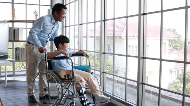 orthopedic walking, Crutches Walks Confidently. Child Step in Rehabilitation with Leg Brace. Asian father helping to support his son, who has a broken ankle