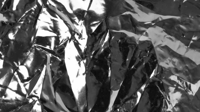 Silver foil textured background, crumpled aluminum pattern loop. Sparkle metal paper wallpaper, glossy solver foil packaging bg, reflective gray food wrapping