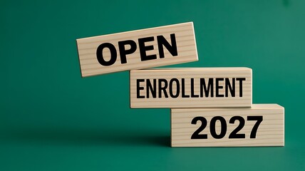 Wooden blocks stacked to display open enrollment 2027 on a solid dark green background, representing healthcare insurance, and benefits sign, up period