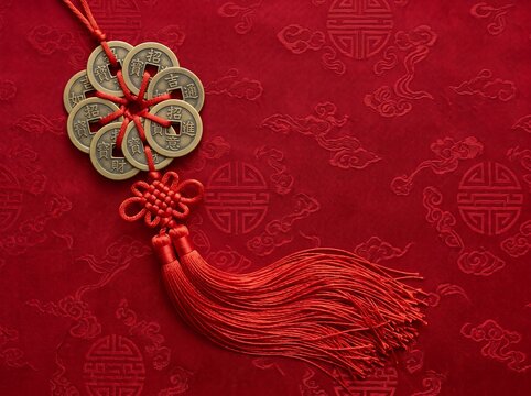 Chinese New Year decoration with red tassel and golden coins on red fabric