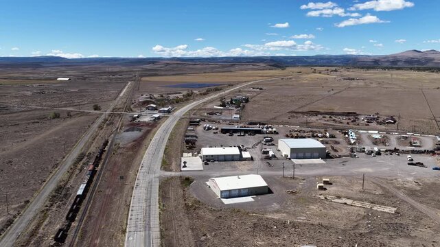 Aerial of industrial and commercial buildings with trucks and heavy equipment on highway 285 in Antonito Colorado