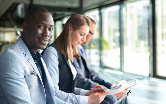 Portrait of smiling African American business man with executives working in background