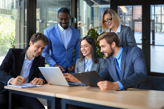 Group of business partners discussing ideas and planning work in office.