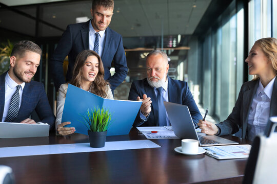 Group of business partners discussing ideas and planning work in office.