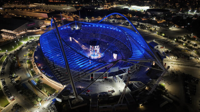 Aerial drone scenic view of live concert illuminated with colorful lights of Anna Vissi popular Greek singer in OAKA sports stadium designed by Santiago Calatrava, Athens, Greece