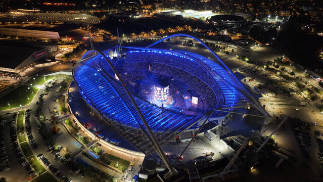 Aerial drone scenic view of live concert illuminated with colorful lights of Anna Vissi popular Greek singer in OAKA sports stadium designed by Santiago Calatrava, Athens, Greece