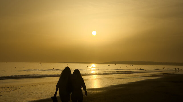  people walking on beach sunset
