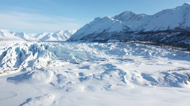 Wide View of Frozen Glacier Ice Fissures and Towering Winter Mountain Peaks