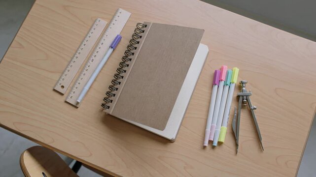 Education and academic planning concept notebook with stationery and drafting tools on a wooden desk overhead view of school supplies for study