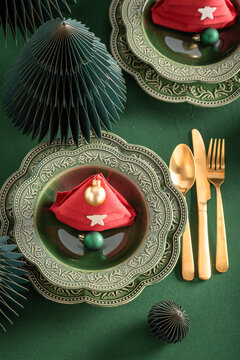 Green holiday table arrangement with Christmas baubles.