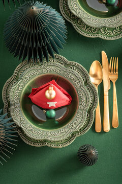 Contemporary green setting decorated with holiday ornaments.