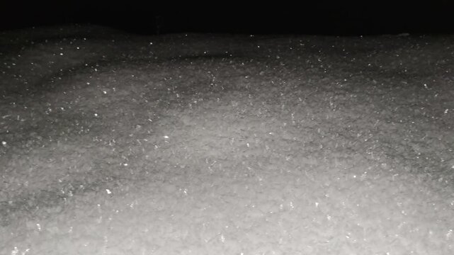 Snow lying on ground at night in Carpathians, frosty air shimmering with icy crystals and sparkling frost, cold winter landscape under moonlight glow