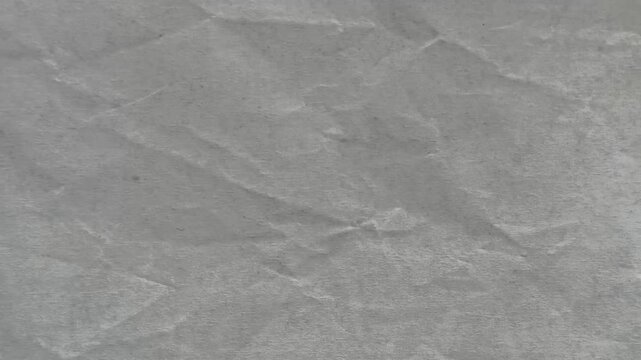 Lite white or gray color shade crumpled paper wrinkled style surface pattern with copy space. Minimal abstract background texture for graphic design use. Stop motion animation loop.