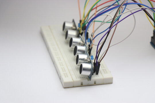 Multiple ultrasonic sensors on breadboard connected via jumper cables to microcontroller for electronics prototyping