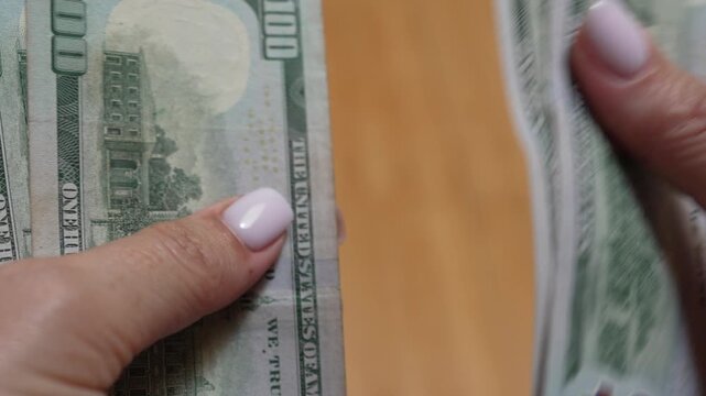 Money, cash, counting, close-up shot of female hands counting one hundred dollar bills for finance and business banking transactions