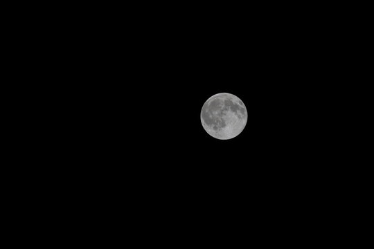 Full moon shining in a dark night sky