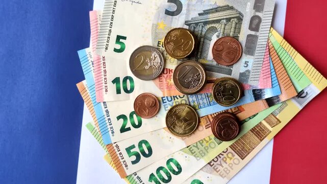 France, French euro cash and cent coins against the background of the flag. Euro cash