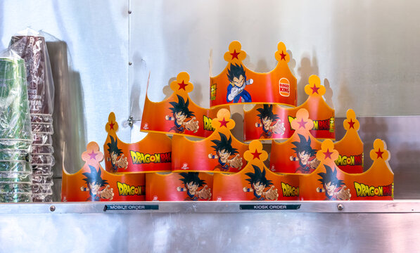 Calgary, Alberta, Canada. September 27, 2026. Stacked themed paper crowns with anime characters on a shelf inside a fast food restaurant.