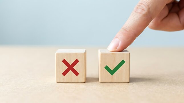 Finger pressing a wooden cube with a green check mark next to another cube with a red cross, decision making and choice concept