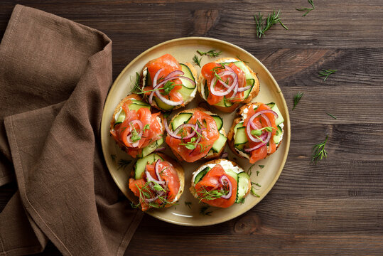 Smoked salmon toasts with cream cheese, fresh cucumber and greens