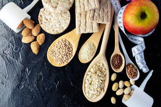 different types of diet bread, round buckwheat crispbread, wheat crispbread and crispbread with oatmeal flakes and wheat grains, flax and sesame seeds, healthy flour - body measuring tape background