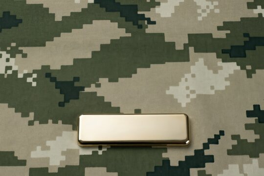 Metallic blank gold plate on military digital camouflage pattern fabric, golden metal tag mock up on army camo background
