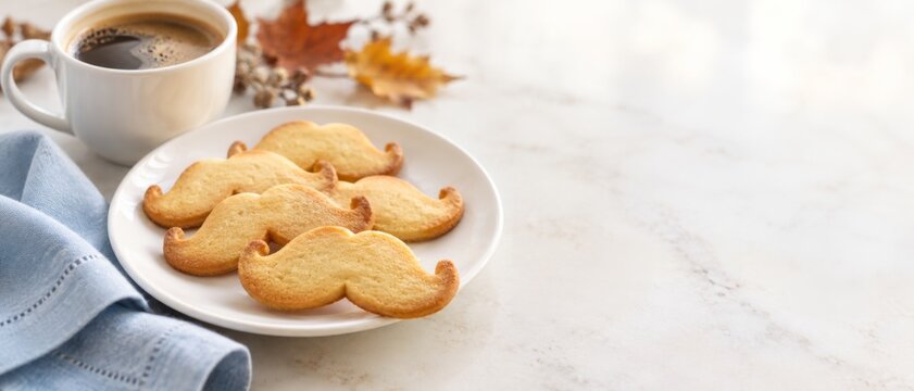 Mustache shaped cookies with coffee on marble table, promoting Movember men health month through seasonal food styling, warm autumn accents, and generous copy space for awareness campaign messaging